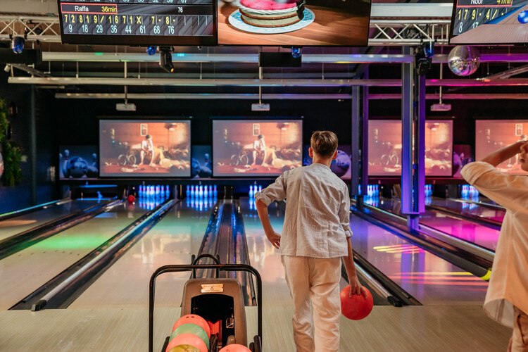 Boy throws bowling ball on bowling lane at Mitland Bowling