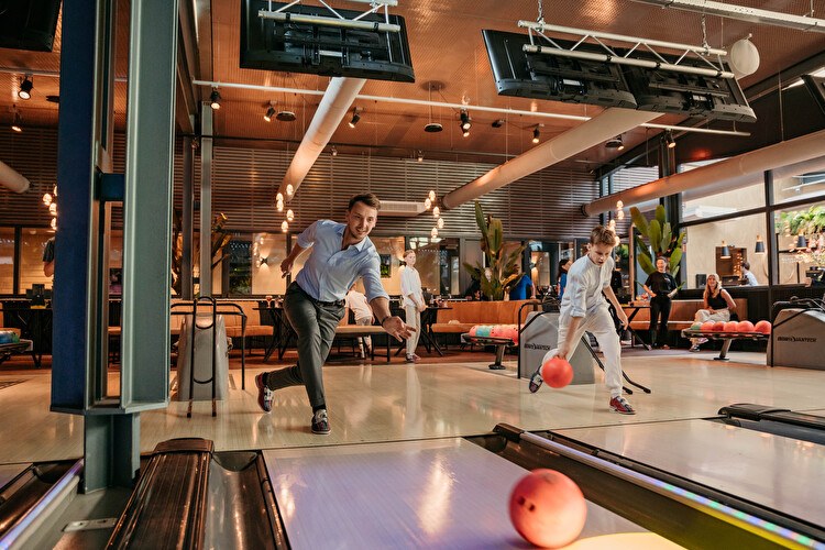 Man en jongen aan het bowlen bij Mitland Bowling