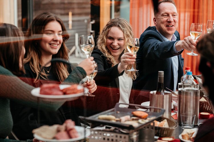 People toasting at the table during table grilling at Restaurant Vlonders