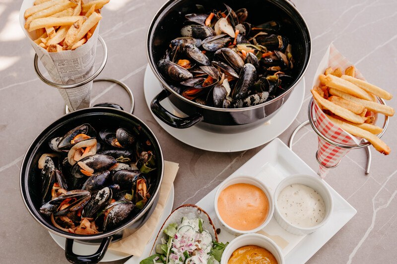 Gedekte tafel met pannen mosselen en frites